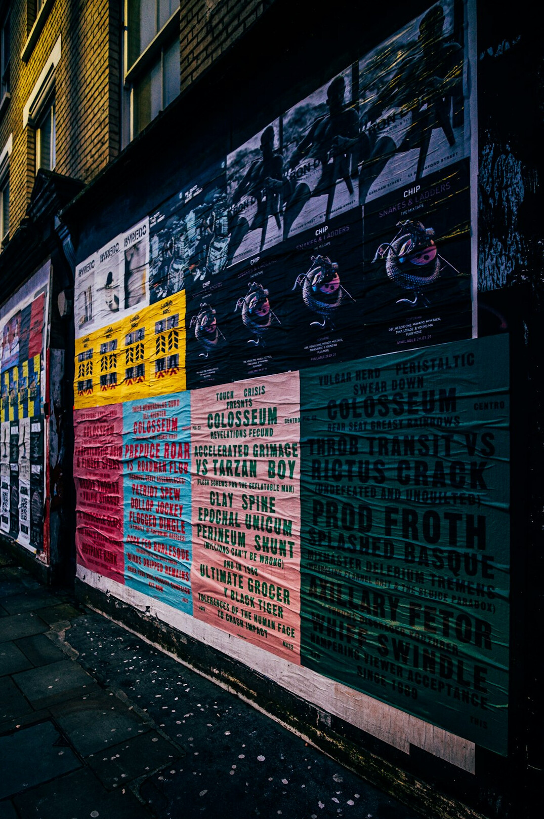 Wall covered with layered vintage advertising posters in bold colours